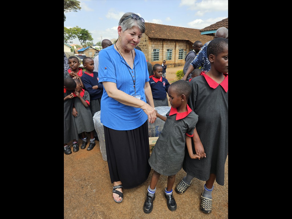 Mildred Catron helping a blind little girl feel secure.